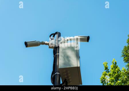 Security cameras and a Wi-Fi station installed on a pole in a public place. Surveillance and security technologies. Security equipment on the streets Stock Photo