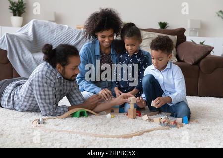 Happy African American parents playing toys with kids.