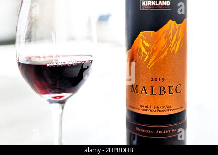 Hollywood, USA - July 13, 2021: Closeup of bottle of Argentina Mendoza Malbec red wine alcohol drink glass Kirkland brand bought at Costco on table wi Stock Photo