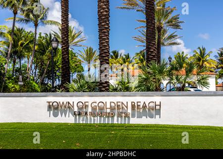 Miami, USA - July 18, 2021: Sign for welcome to Golden Beach town established in 1929 in Miami, Florida with palm trees on sunny day and blue sky Stock Photo