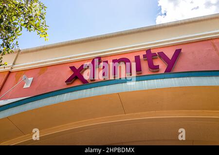 Naples, USA - August 7, 2021: Naples, Florida Comcast Xfinity sign for business office in strip mall closeup of wall and nobody Stock Photo