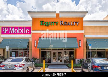 Naples, USA - August 7, 2021: Naples, Florida Equity Realty real estate sign for business office in strip mall with T-Mobile office and parking lot Stock Photo