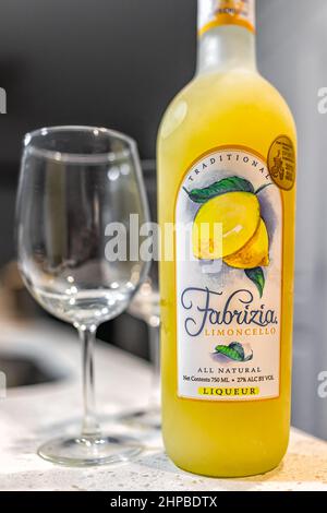 Naples, USA - August 27, 2021: Fabrizia Limoncello all natural liqueur liquor bottle on table with glass made with Italian lemons in New Hampshire Stock Photo