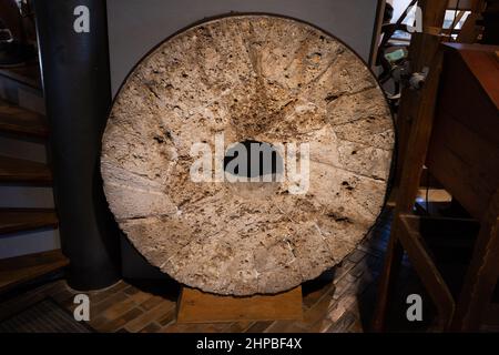 Sandstone millstone in Historic Mill of Sanssouci museum exhibition in Dutch style traditional windmill in city of Potsdam, Germany. Stock Photo