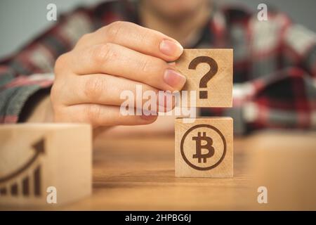 Bitcoin and question mark symbols on wooden cubes. Concept of FAQ, ideas of investment and business plans Stock Photo