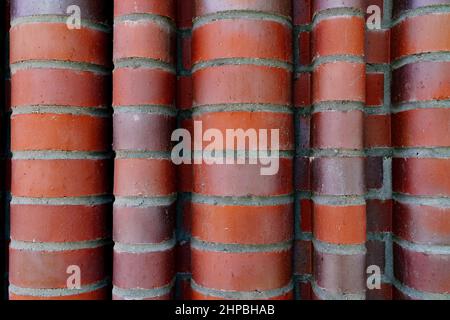 Texture of red curled brick wall, waved, closeup, background Stock Photo