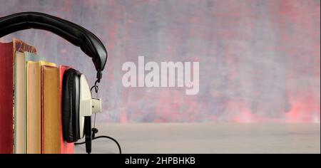 audio book concept with stack of books, and vintage headphones, close up with narrow depth of field and large copy space. Stock Photo