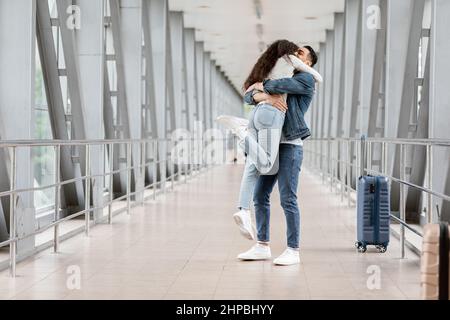 Long-Awaited Meeting. Romantic Young Arab Couple Embracing At Airport After Arrival Stock Photo