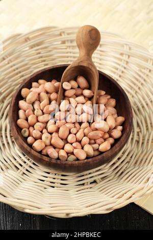 Raw Peanuts on Wooden Bowl with Wooden Scoop Stock Photo