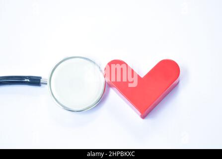 red heart and stethoscope medical equipment for doctor listening pulse of patient on white background Stock Photo