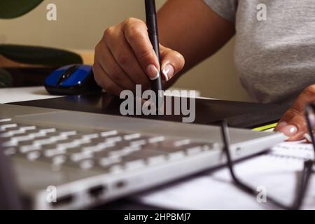 Woman working on graphics tablet with stylus.  Stock Photo
