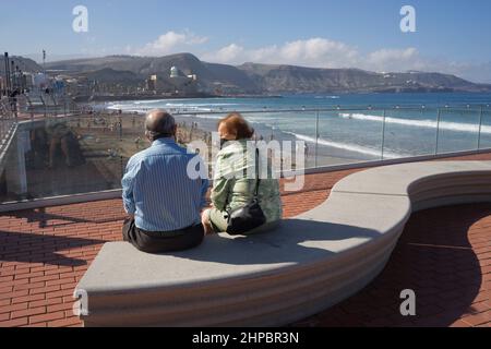 Senior couple wearing face masks due to Covid pandemic enjoying the sun in Las Canteras beach in Las Palmas; Gran Canaria; Spain