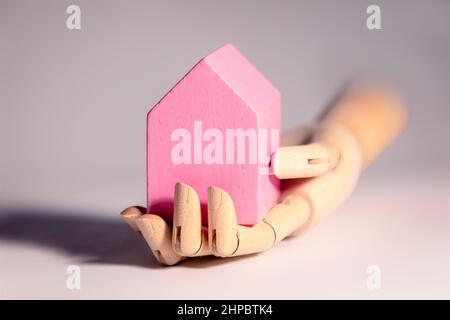 Hand holding house shpaed toy blocks, concept of home ownership, mortage, heritage Stock Photo