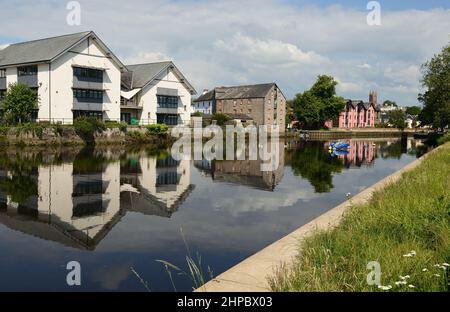 Riverside properties reflected in the river Dart at Totnes, South Devon. Stock Photo