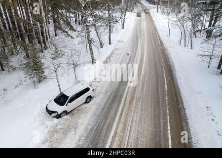 winter accident on the highway due to ice. The car flew into a ditch off the road and crashed into a tree insurance accident. Stock Photo