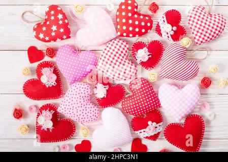 Sewed handmade fabric hearts for valentine day on white wooden background Stock Photo