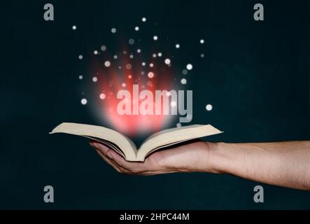 Man holding magic book with hand Stock Photo