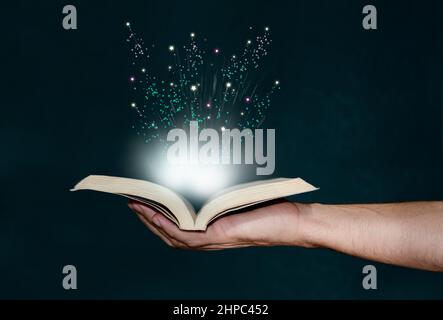Man holding magic book with hand Stock Photo