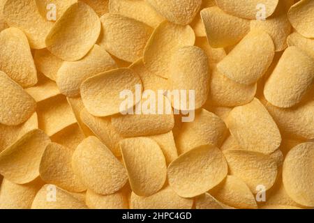 Deep fried crunchy potato chips close up full frame as background Stock Photo