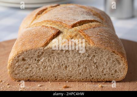 Loaf of white paysan bread, farmers bread close up on a cutting board Stock Photo