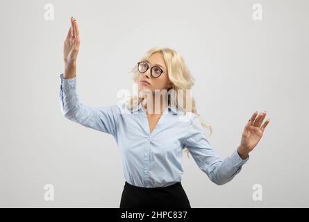 Business innovations concept. Young female entrepreneur touching virtual screen on light background, mockup for design Stock Photo