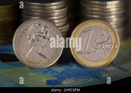Queen Elizabeth and Euro Coins standing on Europe map printed on 20 Euro Bank Note Stock Photo