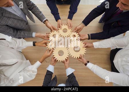Businesspeople connect cogwheels solve business problem Stock Photo