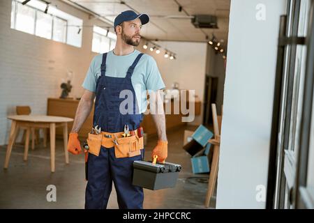 Male worker holding plastic box with tools Stock Photo