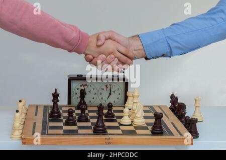 Dad and his daughter  shaking hands after end game of thinking strategy to moving chess figure Stock Photo