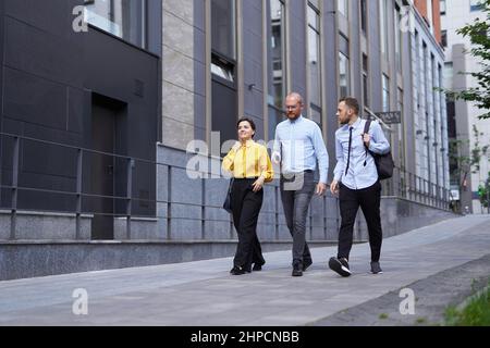 Business or finance industry concept. Team of business persons going on a street in city downtown and discussing project presentation, talking or brainstorming. High quality image Stock Photo