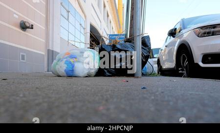 Clear and black plastic trash bags on a sidewalk in San Francisco, California; urban filth, waste, detritus, garbage, and litter; civic responsibility Stock Photo