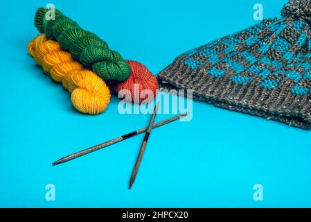 Blue and brown winter hat with a checkered pattern on a blue background closeup. Stock Photo