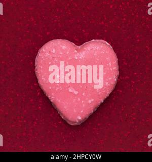 pink valentine shaped biscuit on abstract red background Stock Photo
