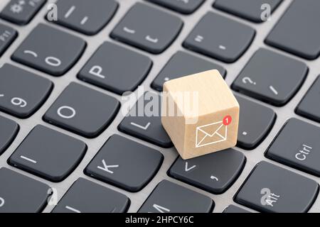 New email graphic on wooden block over laptop keyboard Stock Photo