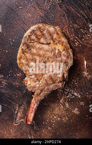 Beef Steak on the bone tomahawk, rib eye. Dark background. Top view. Copy space Stock Photo