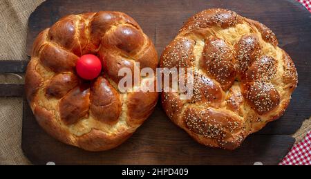 Easter Sweet bread, Greek tsoureki braid top view. Baked fluffy brioche on old rustic baker shovel wood, Stock Photo