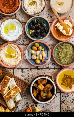 Traditional Turkish Village Breakfast on the ceramic table with pastries, vegetables, greens, spreads, cheeses, fried eggs, jams. Top view Stock Photo