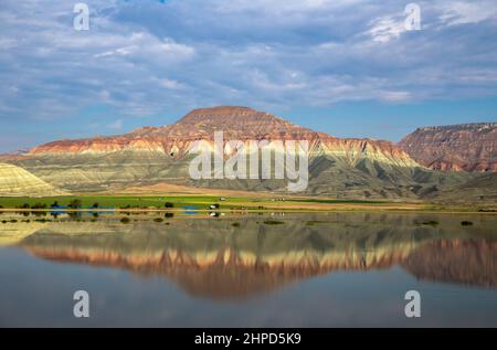 Blue clouds with reflection of colorful mountain in lake Stock Photo
