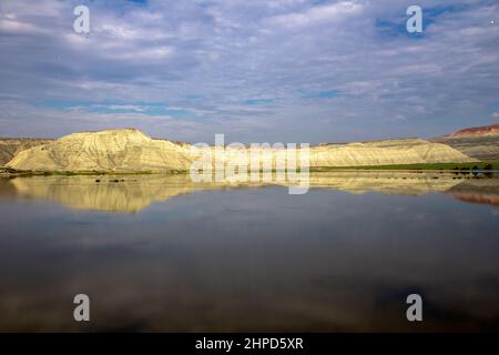 Blue clouds with reflection of colorful mountain in lake Stock Photo