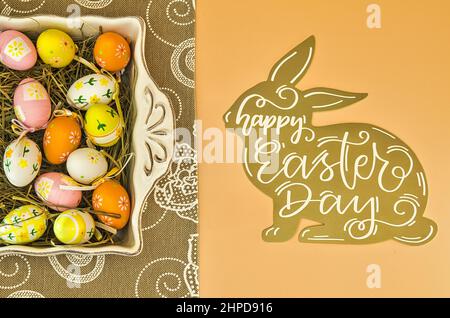 Easter background with painted easter eggs and rabbit wishing happy easter. Stock Photo
