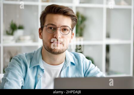 An attractive young man is working on a laptop. Stock Photo