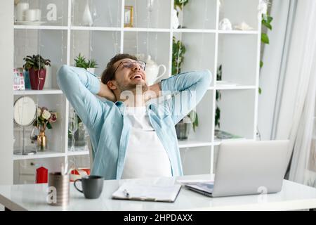 An attractive young man is working on a laptop. Stock Photo