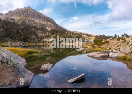 Lake reflecting the mountains, ski station at summer time, Estany primer de Pessons, Andorra, Pyrenees Stock Photo