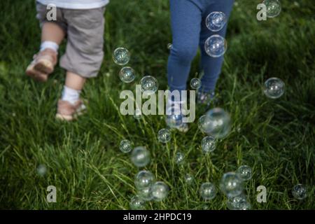 Children with soap bubbles. Soap bubbles and children's hands. Soap entertainment. Stock Photo