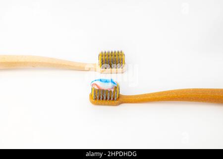 Two ceramic toothbrushes, on one of them applied colored toothpaste, on a white background. Ceramic toothbrush. Stock Photo