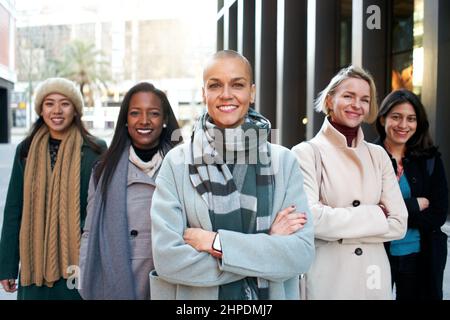 Cheerful portrait of a group of female business looking at the camera. Only woman workers. Group of women smiling with self-confidence. Feminist Stock Photo