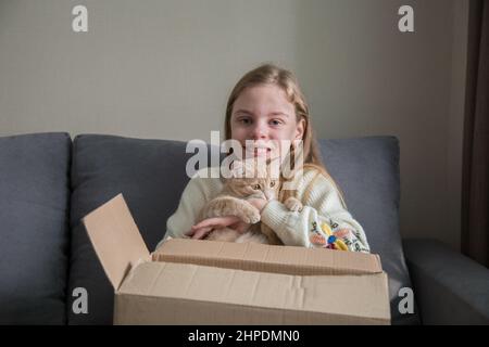 happy girl holding a kitten in a gift box, birthday present Stock Photo