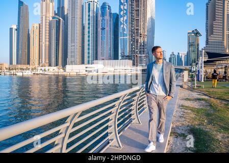 Young man walking at the promenade in Dubai Marina. Stock Photo