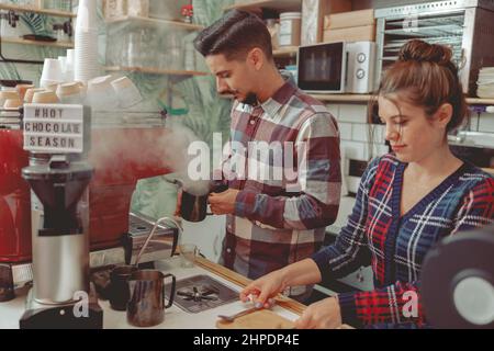 Woman and man barista working in cafe shop Stock Photo
