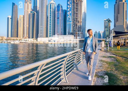 Young man walking at the promenade in Dubai Marina. Stock Photo